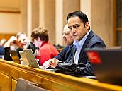 In der Sitzreihe blickt ein Stadtrat in die Kamera