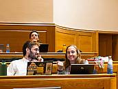 Zwei Stadtratsmitglieder hinter aufgeklappten Laptops im Gespräch