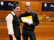 Stadtratsmitglied und Ratsweibel posieren im Grossratssaal des Rathauses