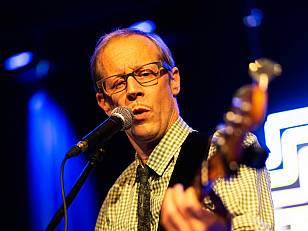 Der Stadtratsweibel mit Bassgitarre singt am Mikrofon