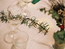 Aufnahme des Tischgedecks mit grünen Servietten und einem Zweig als Deko.