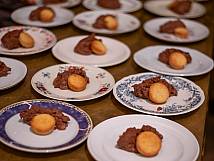 Aufgereihte Teller mit Mousse und Gebäck.