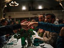 Zwei Personen schütteln sich die Hände über den Tisch hinweg.