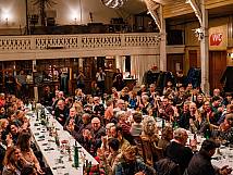 Aufnahme des ganzen Saals. Alle Anwesenden blicken Richtung Bühne.