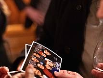 Zwei Personen halten Ausdrucke von Gruppenbildern in der Hand.