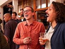 Die Stadträte Chandru Somasundaram und Dominik Fitze mit Glas auf der Terrasse beim Apéro.